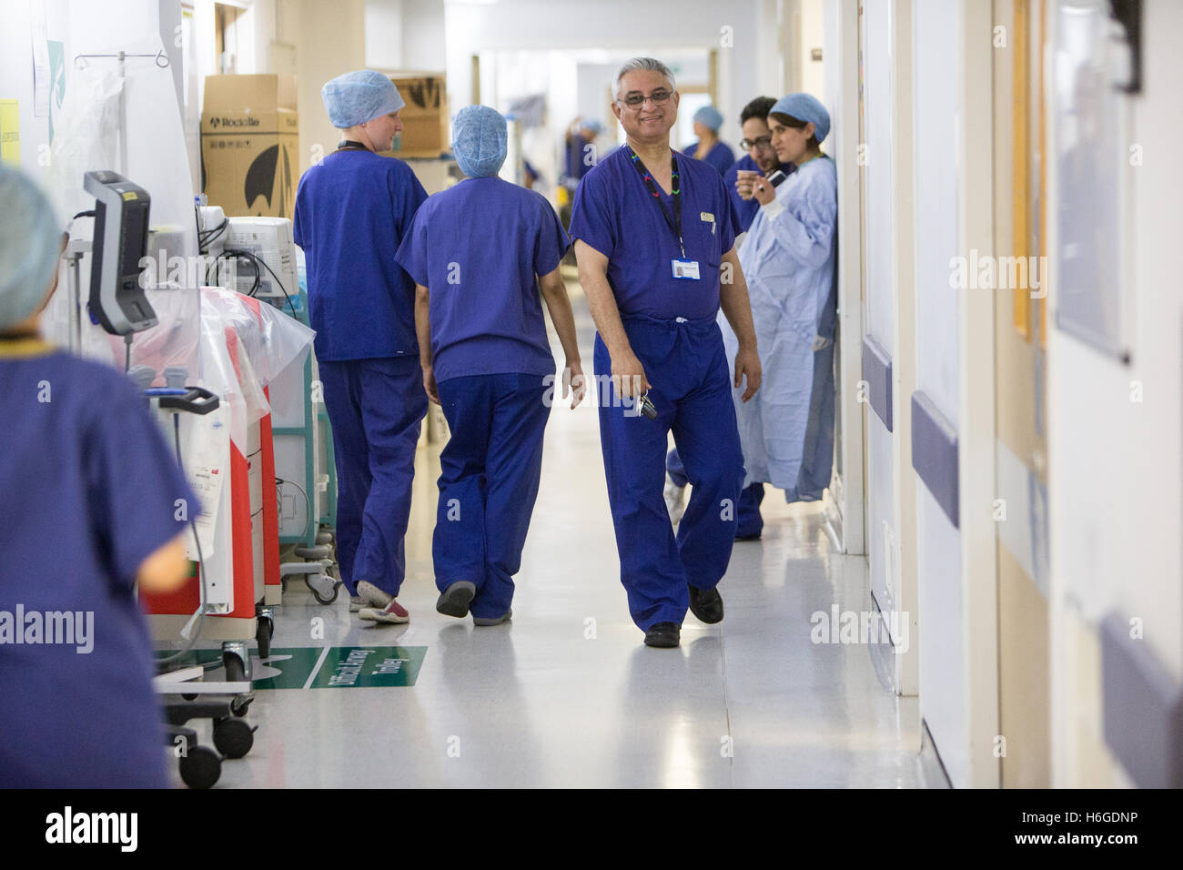 Los médicos, enfermeras y cirujanos en un hospital del NHS corredor vistiendo scrubs Foto de stock