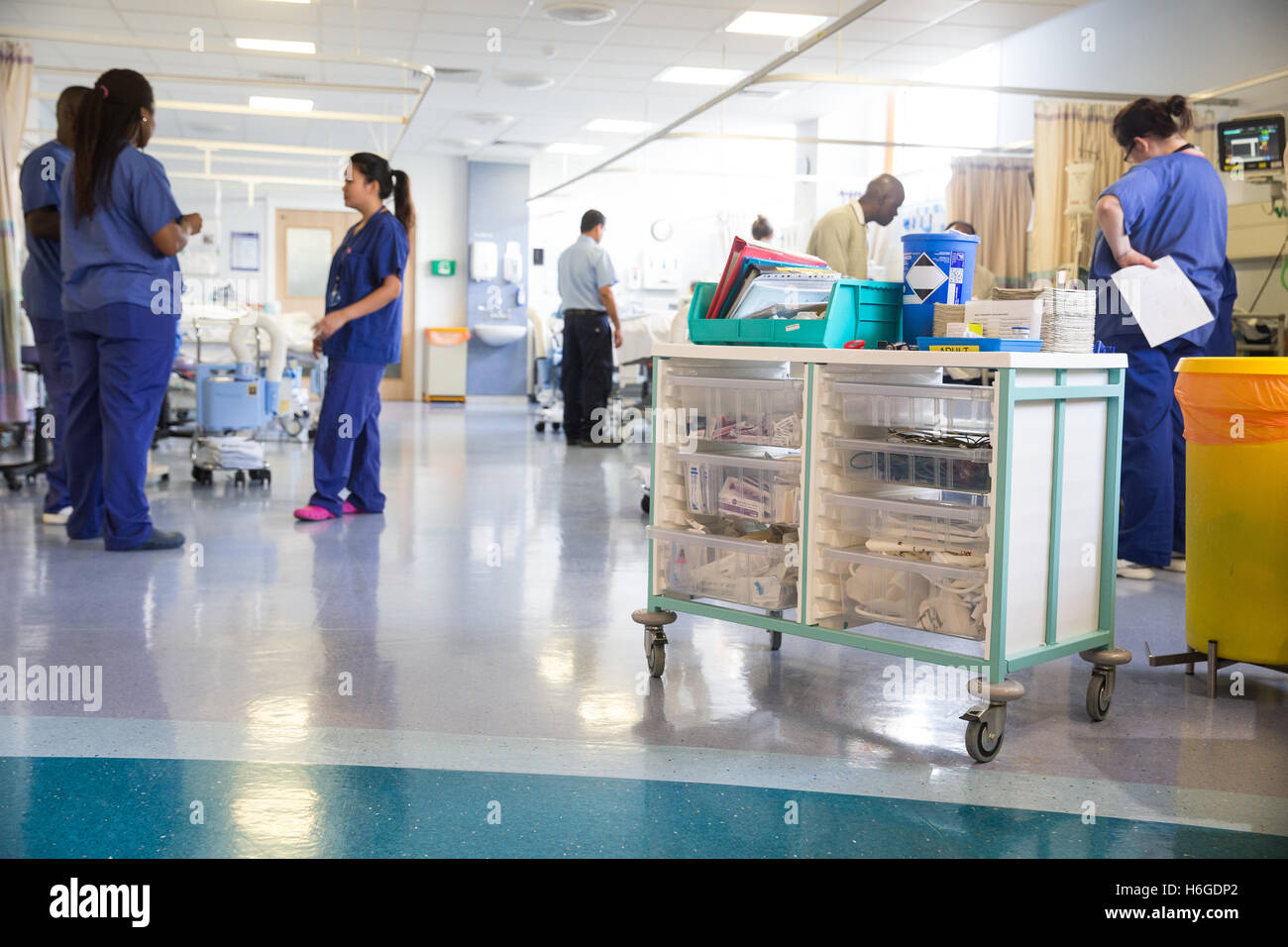 Una concurrida sala de un hospital con las enfermeras con una droga trolley en primer plano Foto de stock