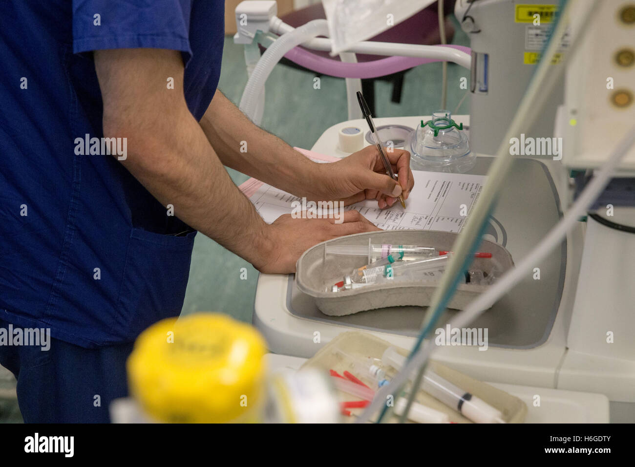 Un teatro techician registra los medicamentos administrados a los pacientes antes de la operación Foto de stock