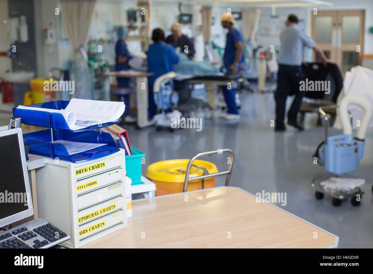 Estación de trabajo en una sala de hospital con enfermeras atendiendo a las necesidades de los pacientes Foto de stock
