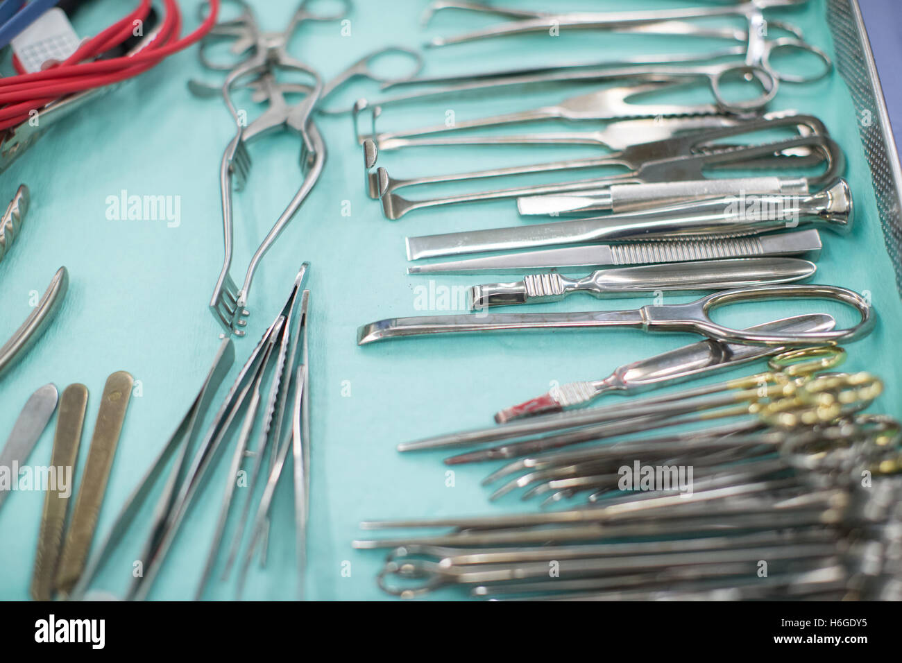 Instrumentos quirúrgicos,abrazaderas,bisturís y tijeras establecidos en una bandeja en el quirófano Foto de stock