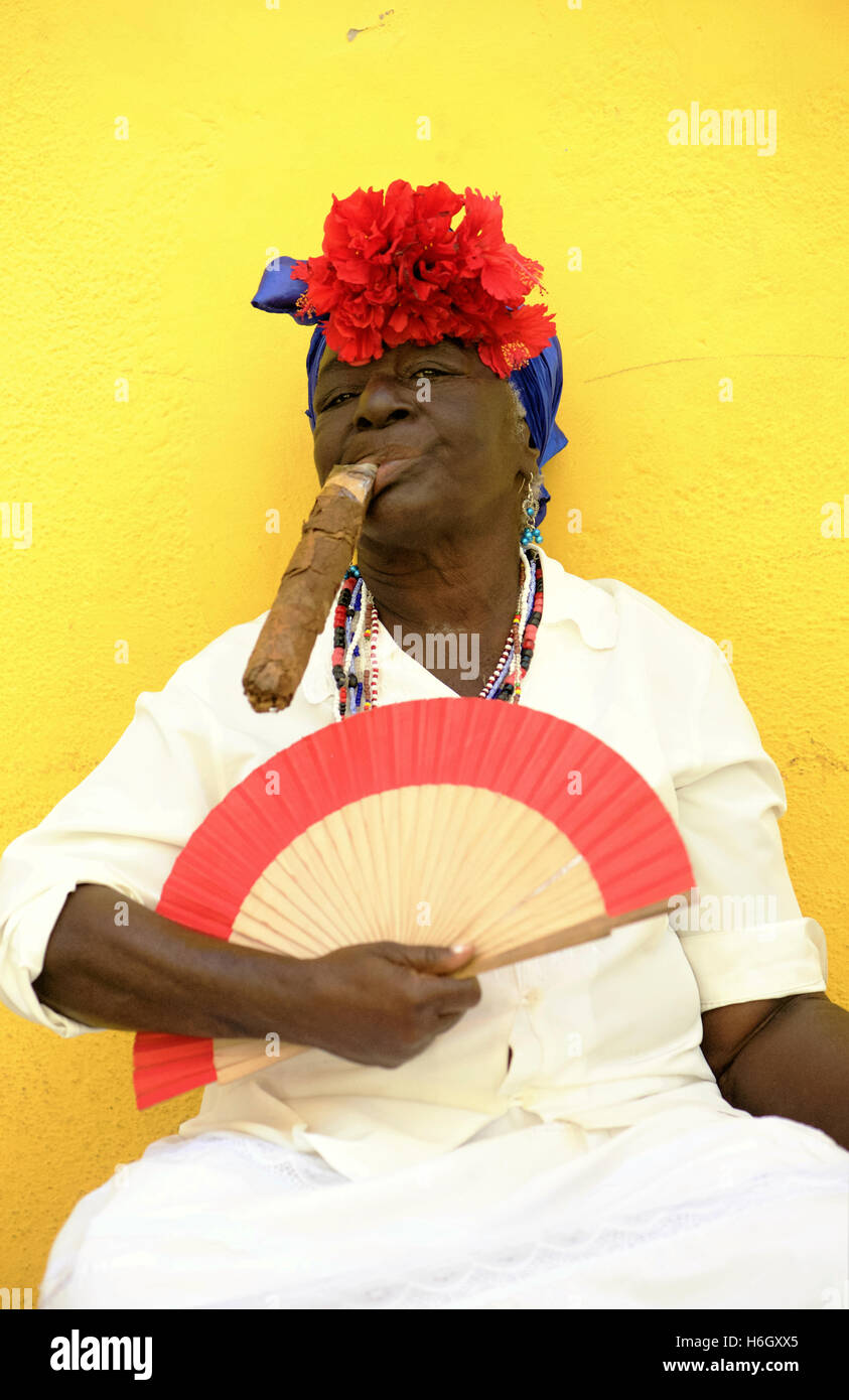 Mujer con cigarro sentado por la calle de La Habana. Foto de stock
