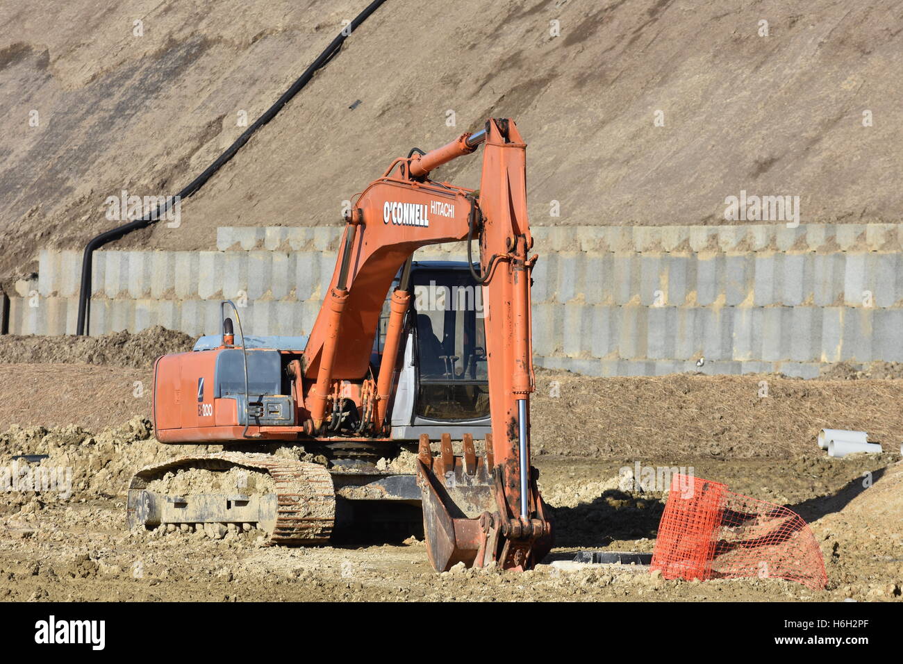 Excavadora Hitachi rojo sobre un fondo fangoso sitio de trabajo. Foto de stock