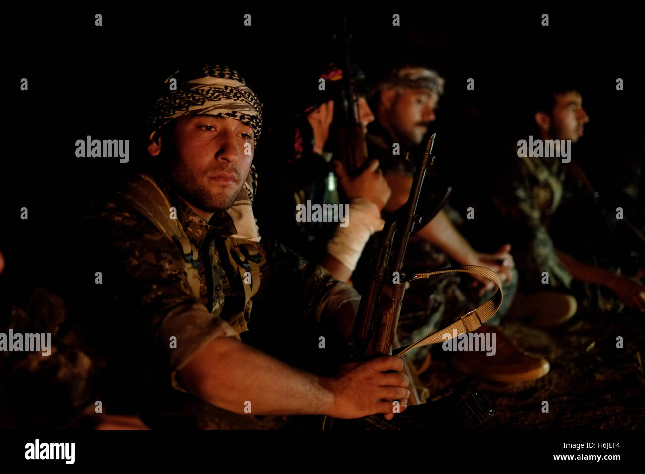 Combatientes de las unidades de protección del pueblo kurdo YPG emplazamiento alrededor de una hoguera en Al-hasakah Hassakeh o distrito en el norte de Siria Foto de stock