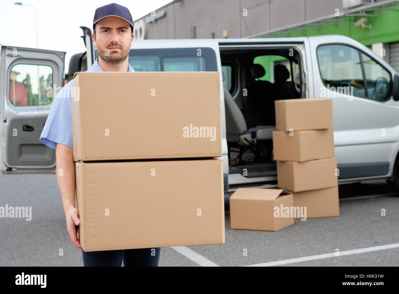 Retrato de confianza courier express junto a su camioneta de entrega Foto de stock