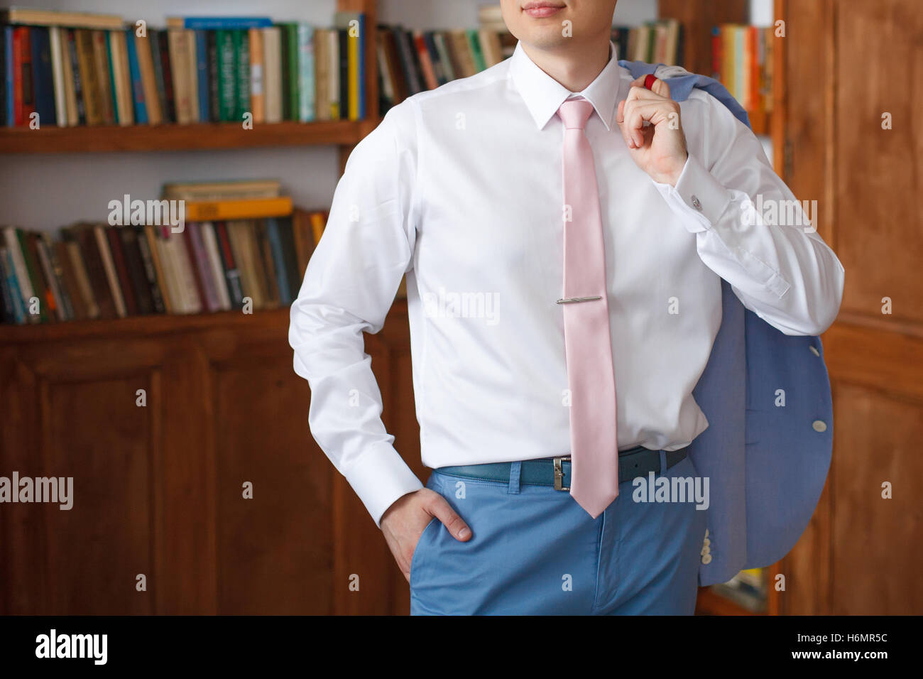 El hombre con la camisa blanca y corbata rosa celebración traje chaqueta  Fotografía de stock - Alamy