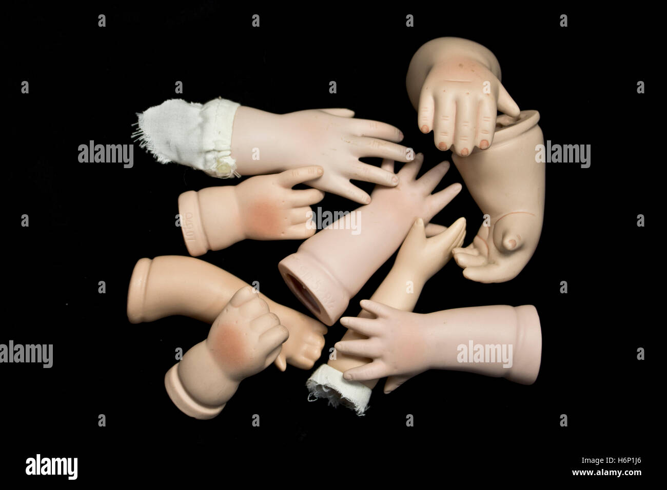 Las partes del cuerpo de muñecas rotas de manos y brazos sobre fondo negro  Fotografía de stock - Alamy