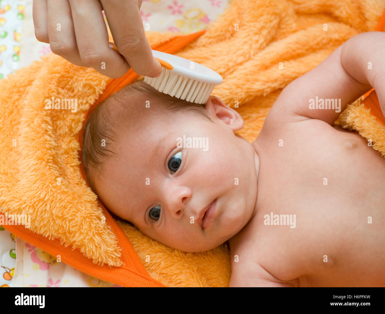 Mamá peine a un bebé recién nacido con un cepillo especial para el cabello.  Higiene del bebé Fotografía de stock - Alamy