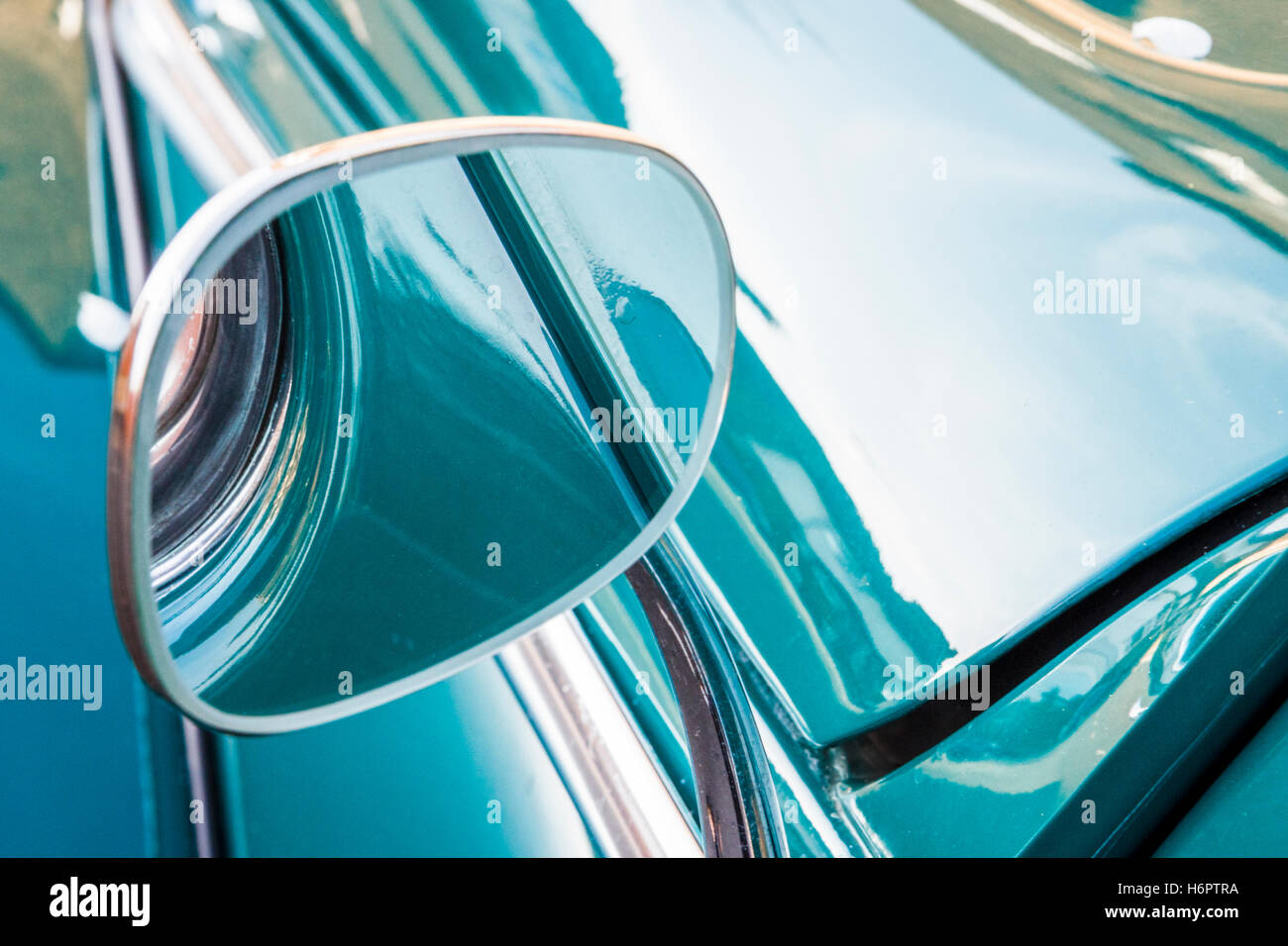Resumen cerca de espejo de ala y reflexiones sobre el capó de un brillante azul-verde Escarabajo Volkswagon coche Foto de stock