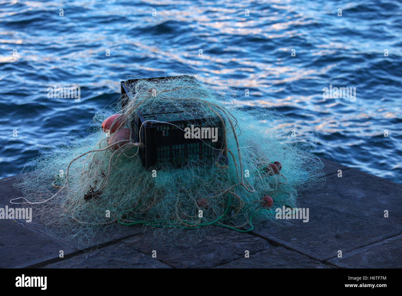 Caja de plástico llena de rojo blanco red de pescar, enormes carrozas cuerda de nylon utilizados en la industria de redes de pesca de nylon trenzado poliestireno flotador. Foto de stock
