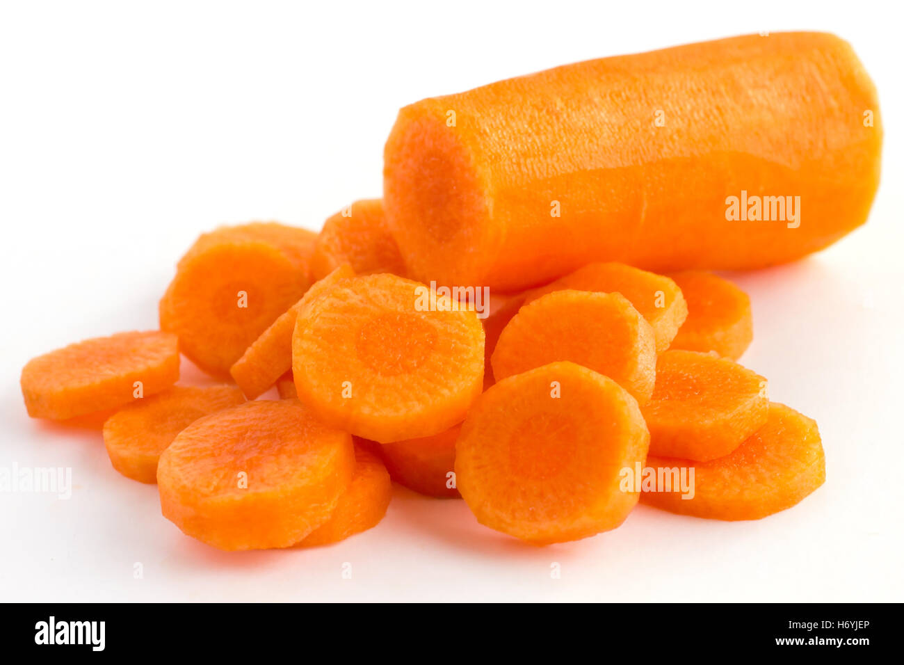 Zanahoria cortados en círculos y dispuestos sobre una superficie blanca Foto de stock