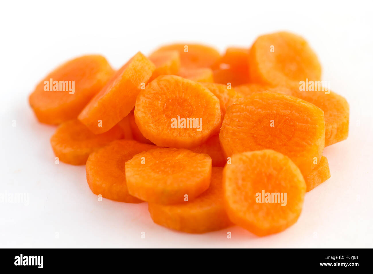 Zanahoria cortados en círculos y dispuestos sobre una superficie blanca Foto de stock