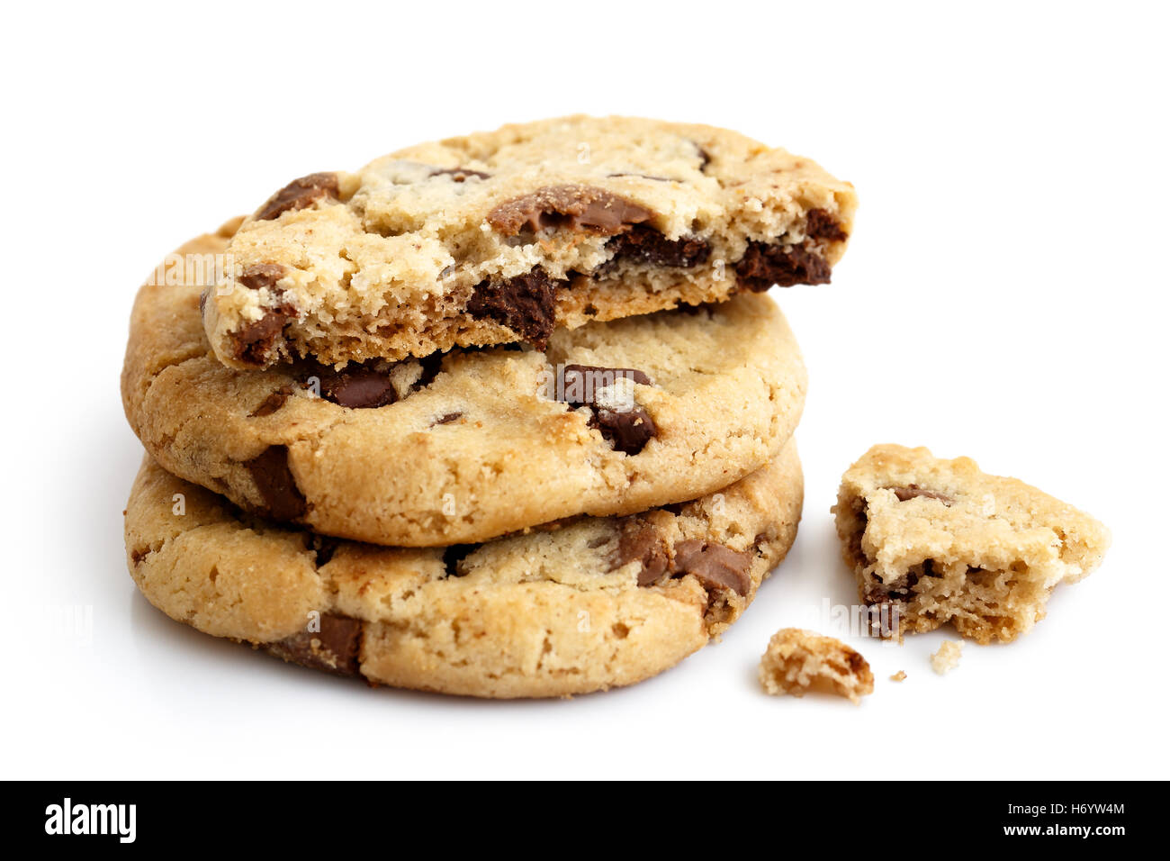 Una pila de tres galletas con trocitos de chocolate de luz aislados. La mitad con migas. Foto de stock
