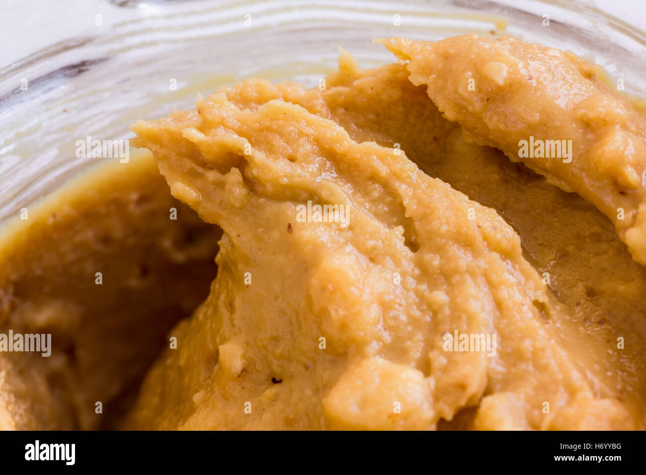 Remolino de mantequilla de cacahuete crujiente en una jarra de cristal abierto Foto de stock