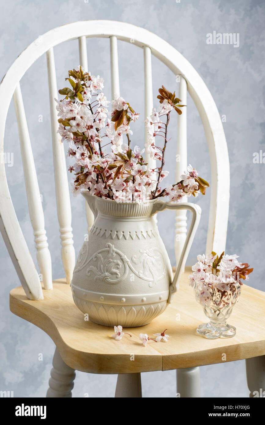 Antique jarra llena de primavera florecen en silla Foto de stock