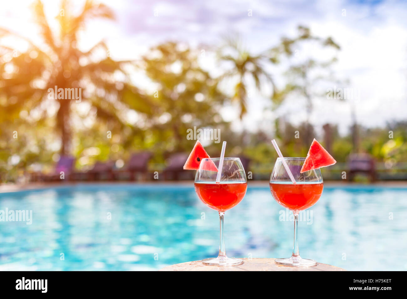 Dos hermosos cócteles o zumos frescos con piscina tropical y antecedentes - vacaciones de verano en un complejo de relajación Foto de stock