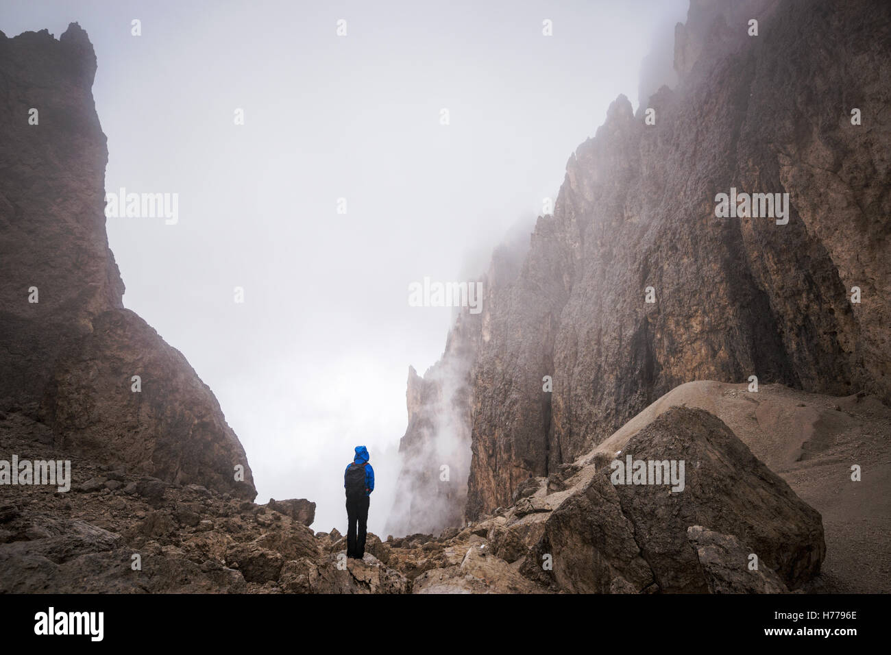 Mujer joven de pie en las montañas Dolomitas, Val Gardena, Tirol del Sur, Italia Foto de stock