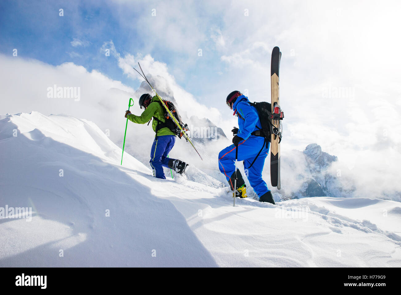 Dos esquiadores caminando en los Dolomitas con skies en su espalda, el Tirol del Sur, Italia Foto de stock