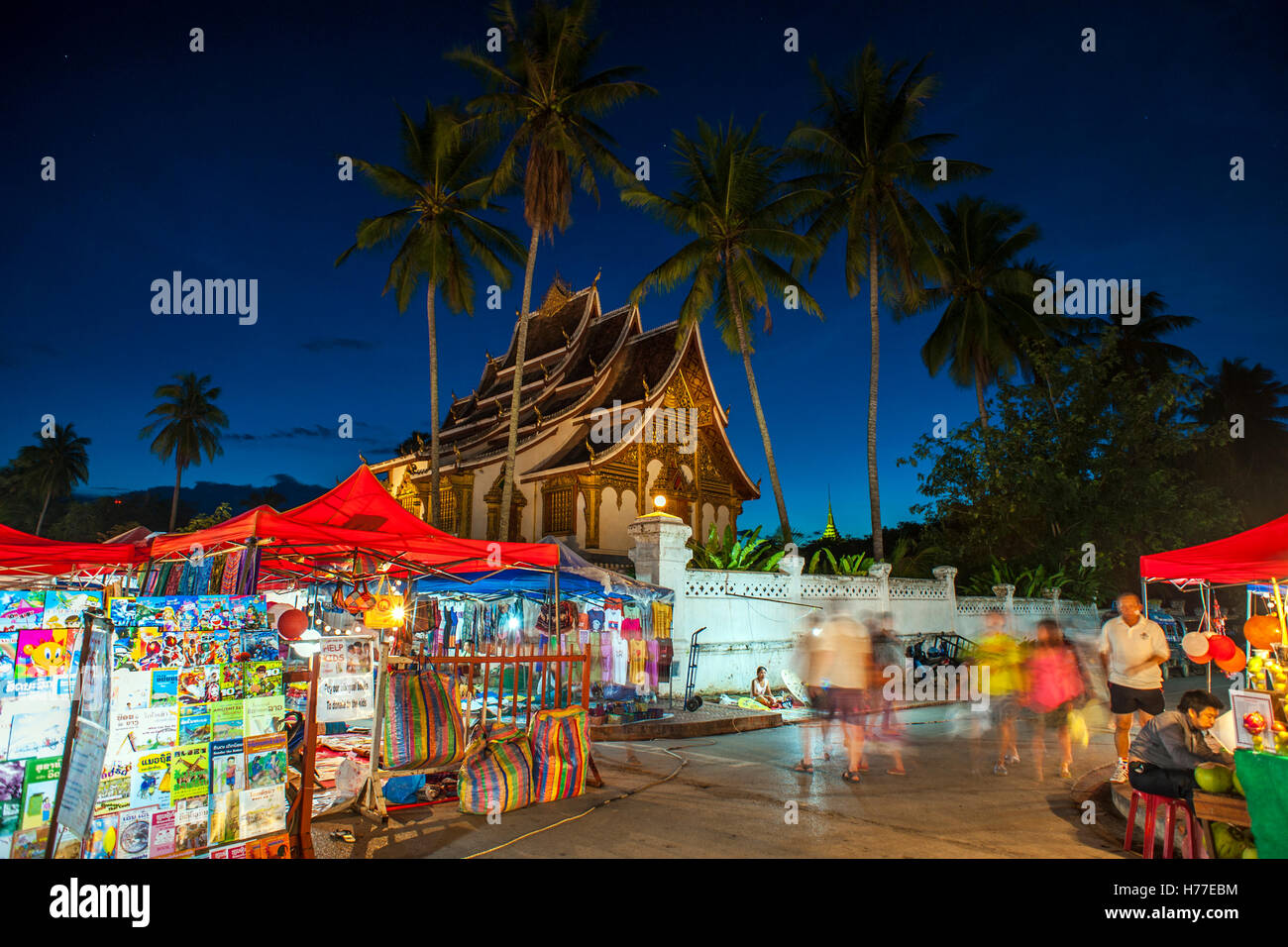 El mercado nocturno de Hmong con Haw Pha Bang templo en el fondo en el centro de Luang Prabang. Foto de stock
