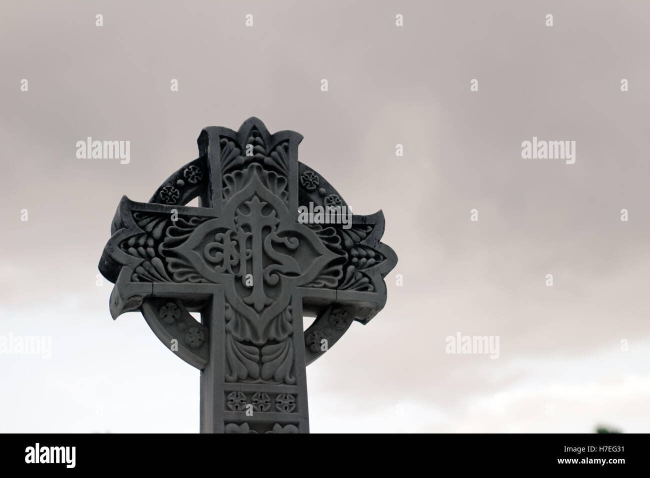 Cruz de piedra esculpida con símbolos religiosos Foto de stock