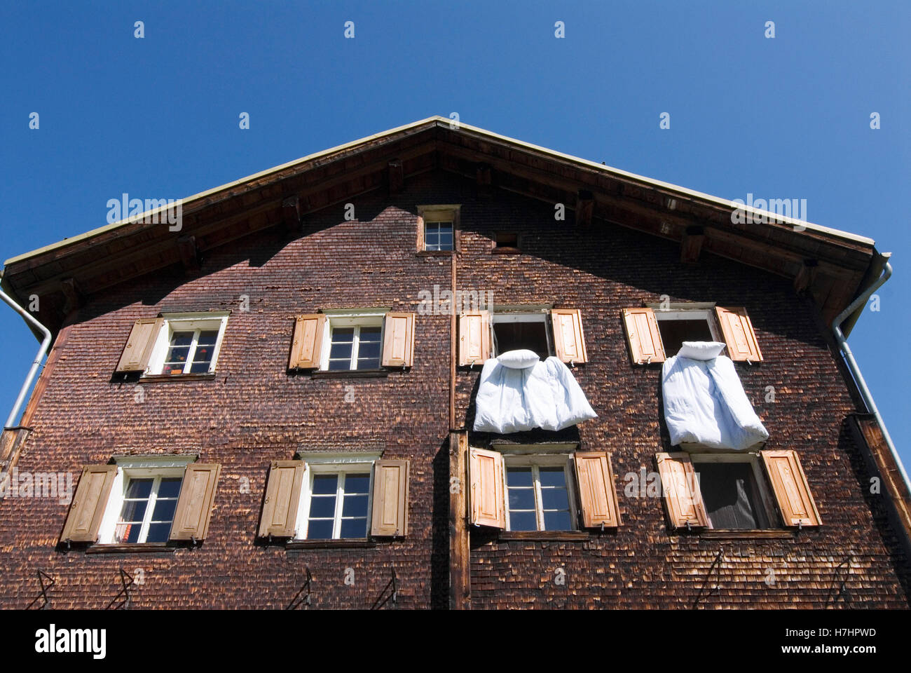 Ropa colgando de las ventanas de una casa de madera en Glas, cantón de los Grisones, Suiza, Europa Foto de stock