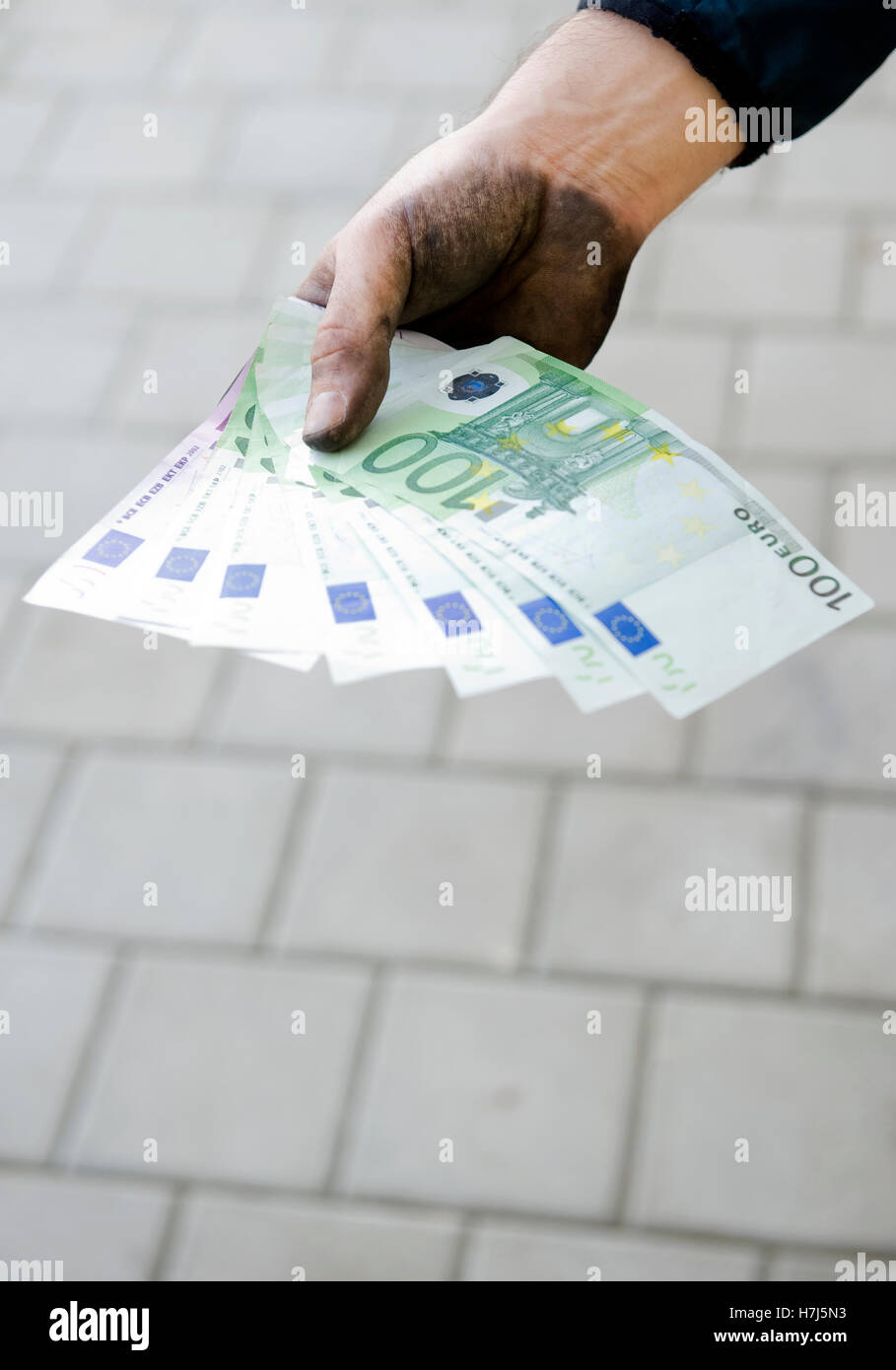 Imagen simbólica de dinero negro, trabajador manual con las manos sucias la celebración de billetes Foto de stock