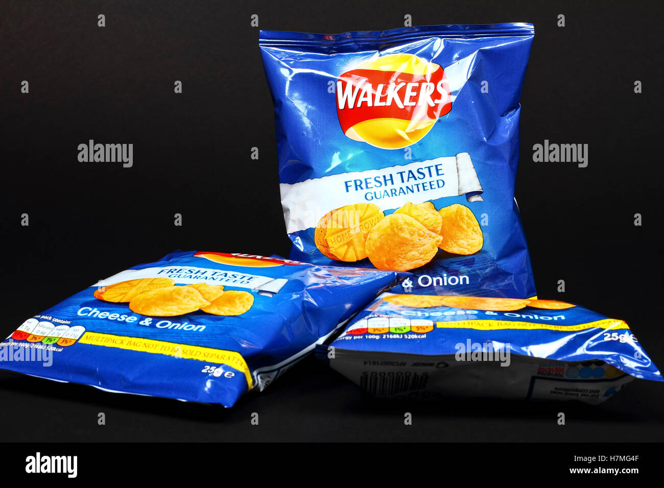 Caminantes de sabor a queso y cebolla fritas aislado en un fondo negro Foto de stock