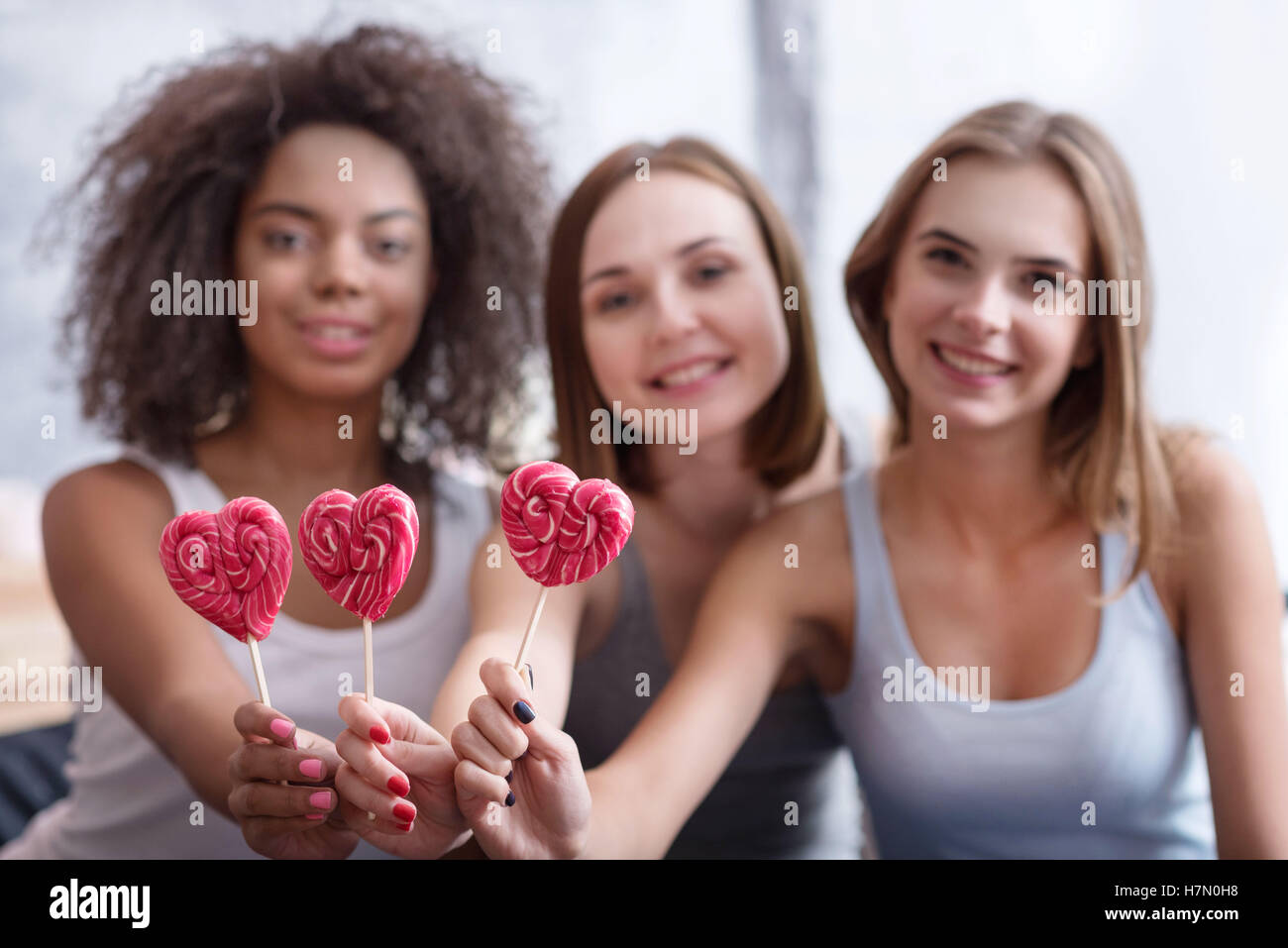 Las niñas sonriente Celebración lollipops Foto de stock