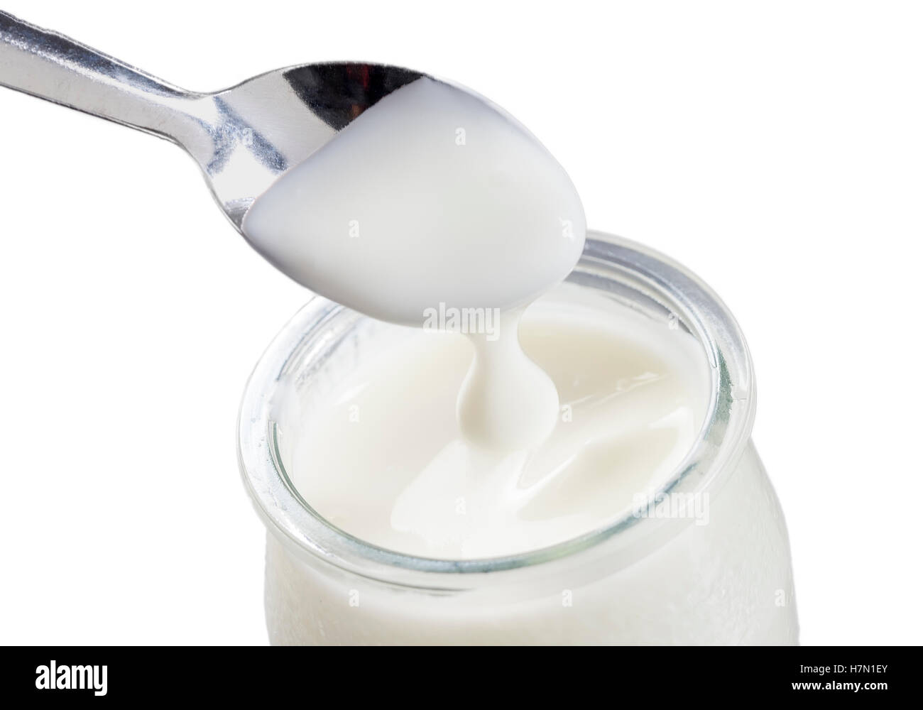 El yogur con una cuchara aislado sobre fondo blanco. Foto de stock