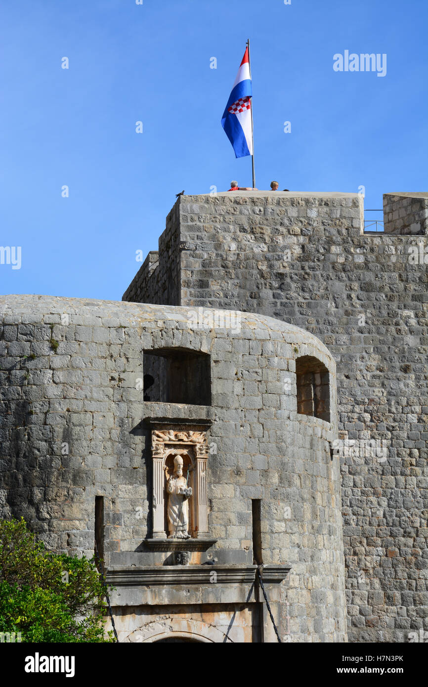 La bandera croata por encima de la Puerta Pile Entrada a la antigua ciudad amurallada de Dubrovnik. Foto de stock