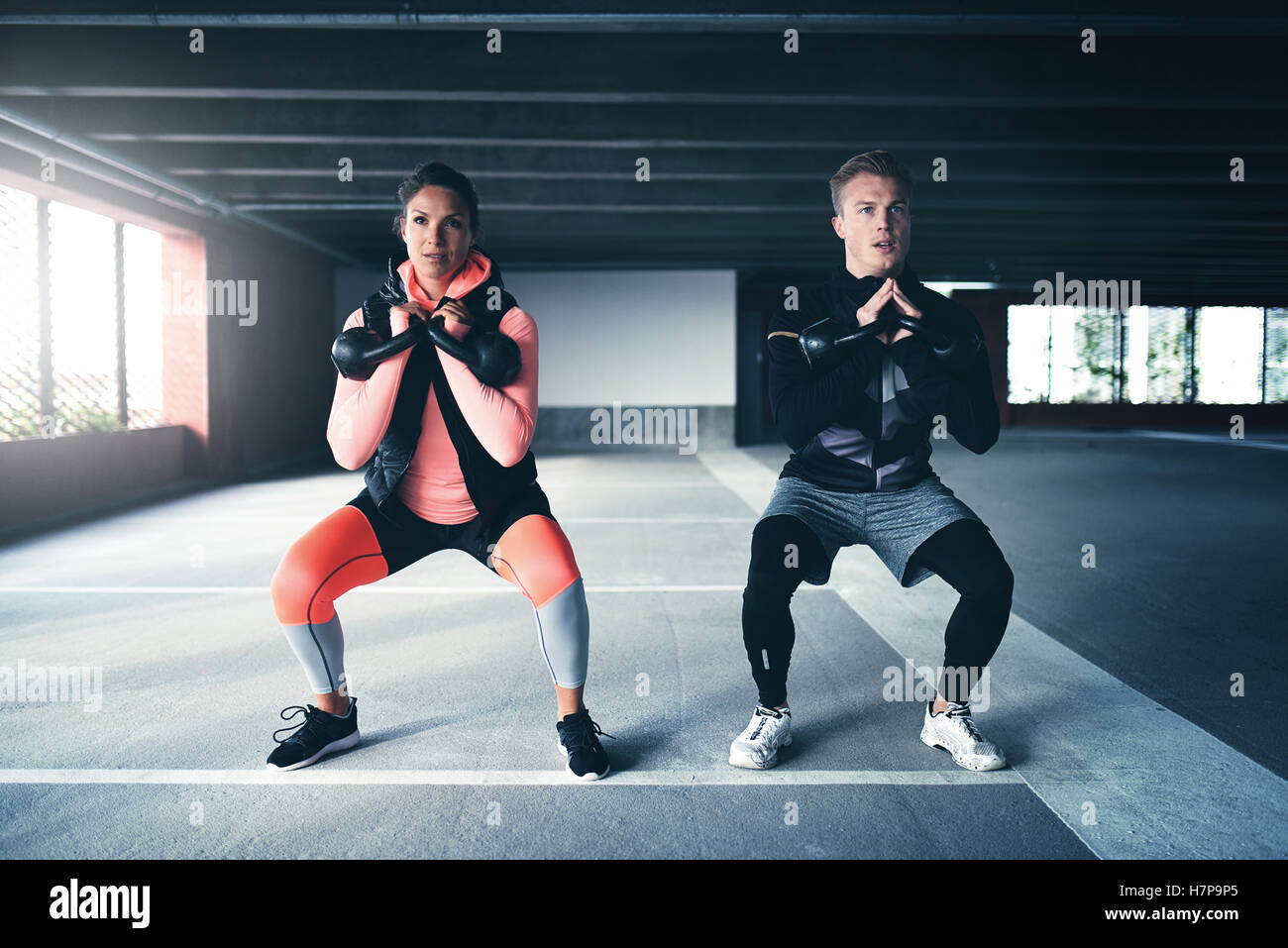 Hombre y mujer el ejercicio con pesas en el entorno urbano, vistiendo ropa  deportiva Fotografía de stock - Alamy