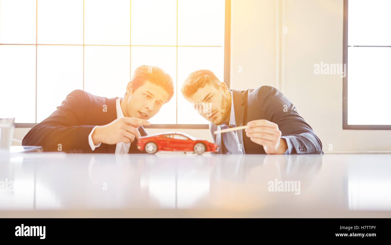 Dos diseñadores discutiendo coche innovador modelo de diseño en el arranque Foto de stock