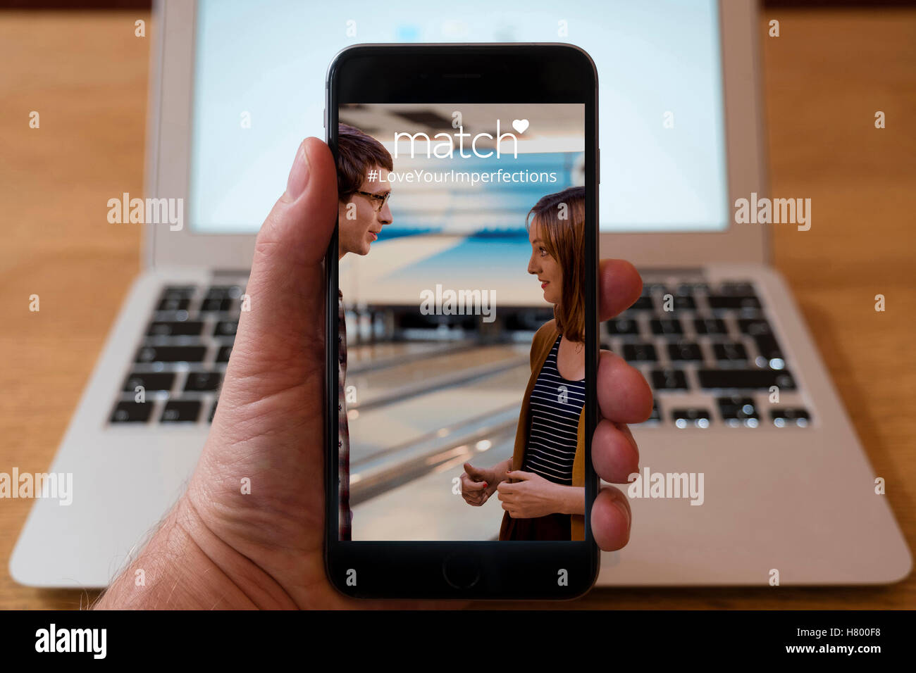 Usando el iPhone Smartphone Mostrar página de Match.com el online dating website Foto de stock