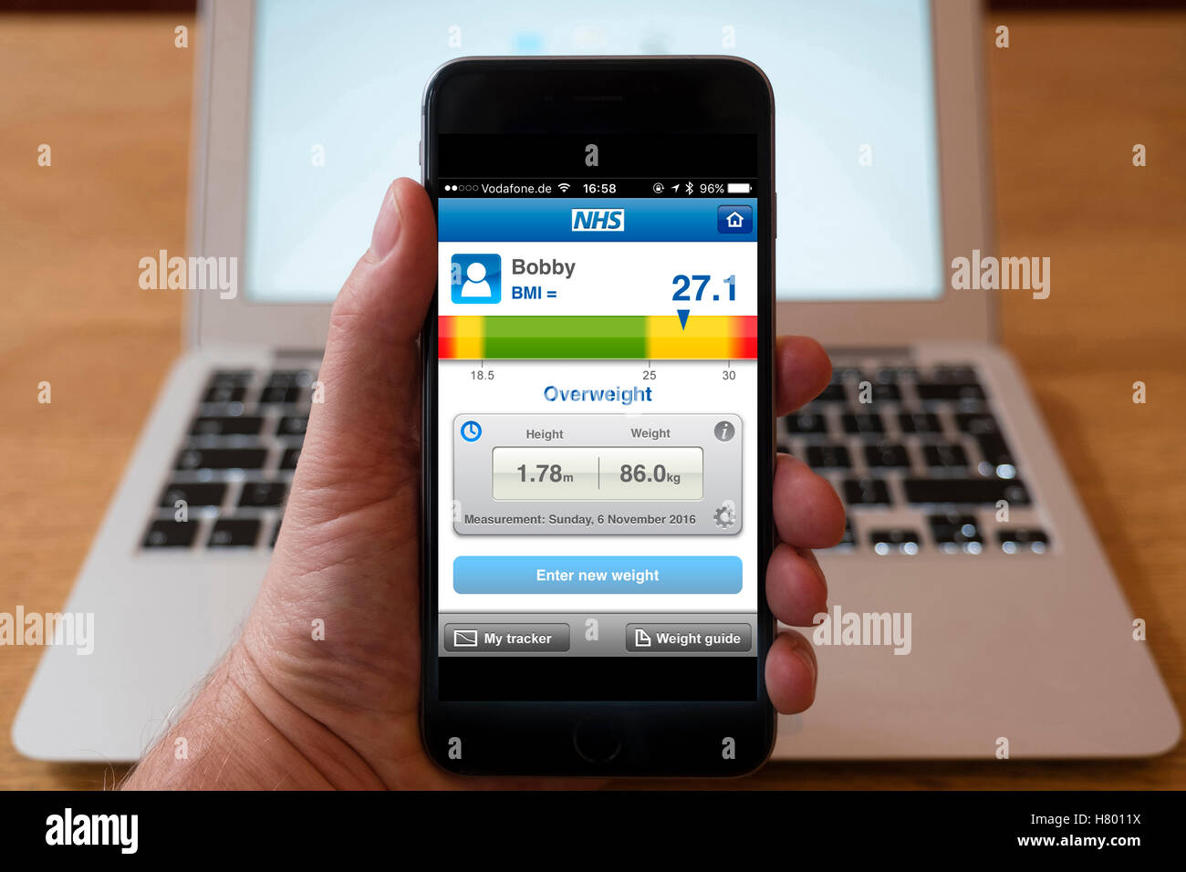Usando el iPhone Smartphone Mostrar NHS (Servicio Nacional de Salud) el IMC (índice de masa corporal) calculadora Foto de stock