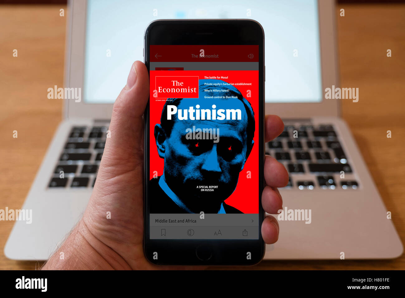 Usando el iPhone Smartphone para mostrar la portada del periódico El Economista de actualidad Foto de stock