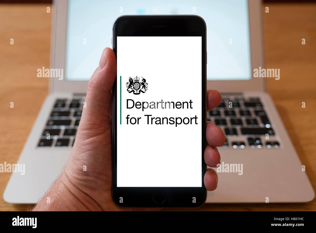 Usando el iPhone Smartphone para mostrar el logotipo del Departamento de Transportes del Reino Unido. Foto de stock