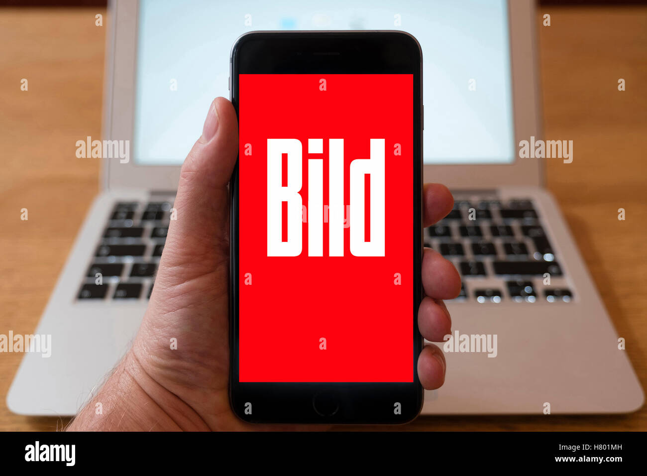 Usando el iPhone Smartphone para mostrar el logotipo de la revista sensacionalista alemán Bild Foto de stock