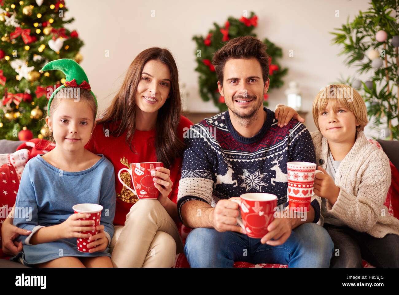 Familia bebiendo chocolate caliente en Navidad Foto de stock