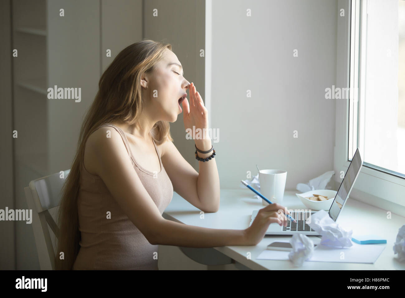 Perfil retrato de mujer atractiva del bostezo en el portátil Foto de stock