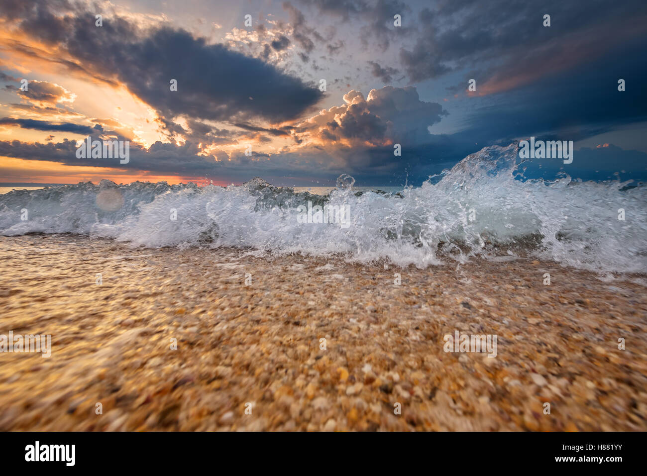 Colorido destino de playa un amanecer o atardecer con hermosas olas Foto de stock