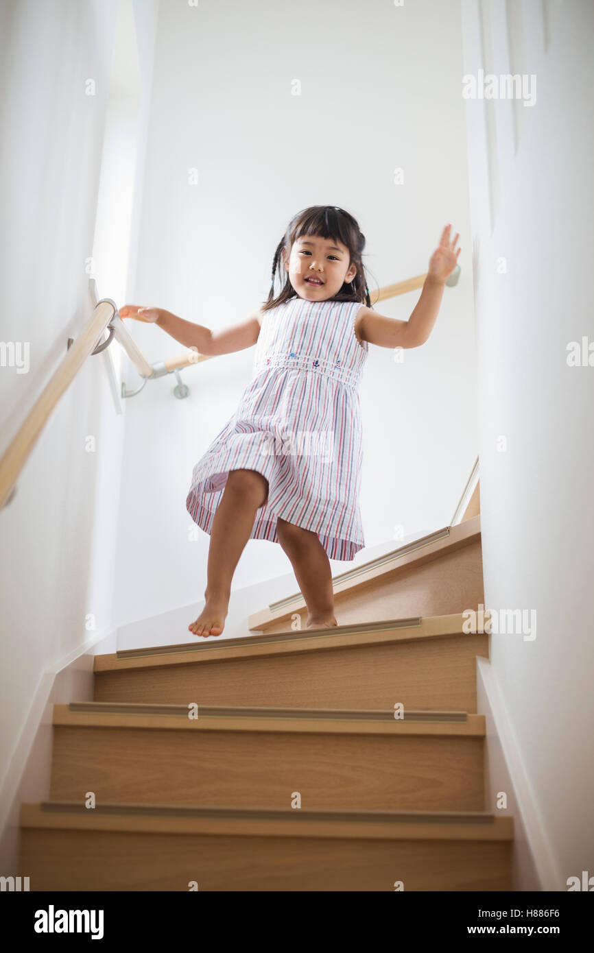 Casa de familia. Una niña bajando las escaleras Fotografía de stock - Alamy
