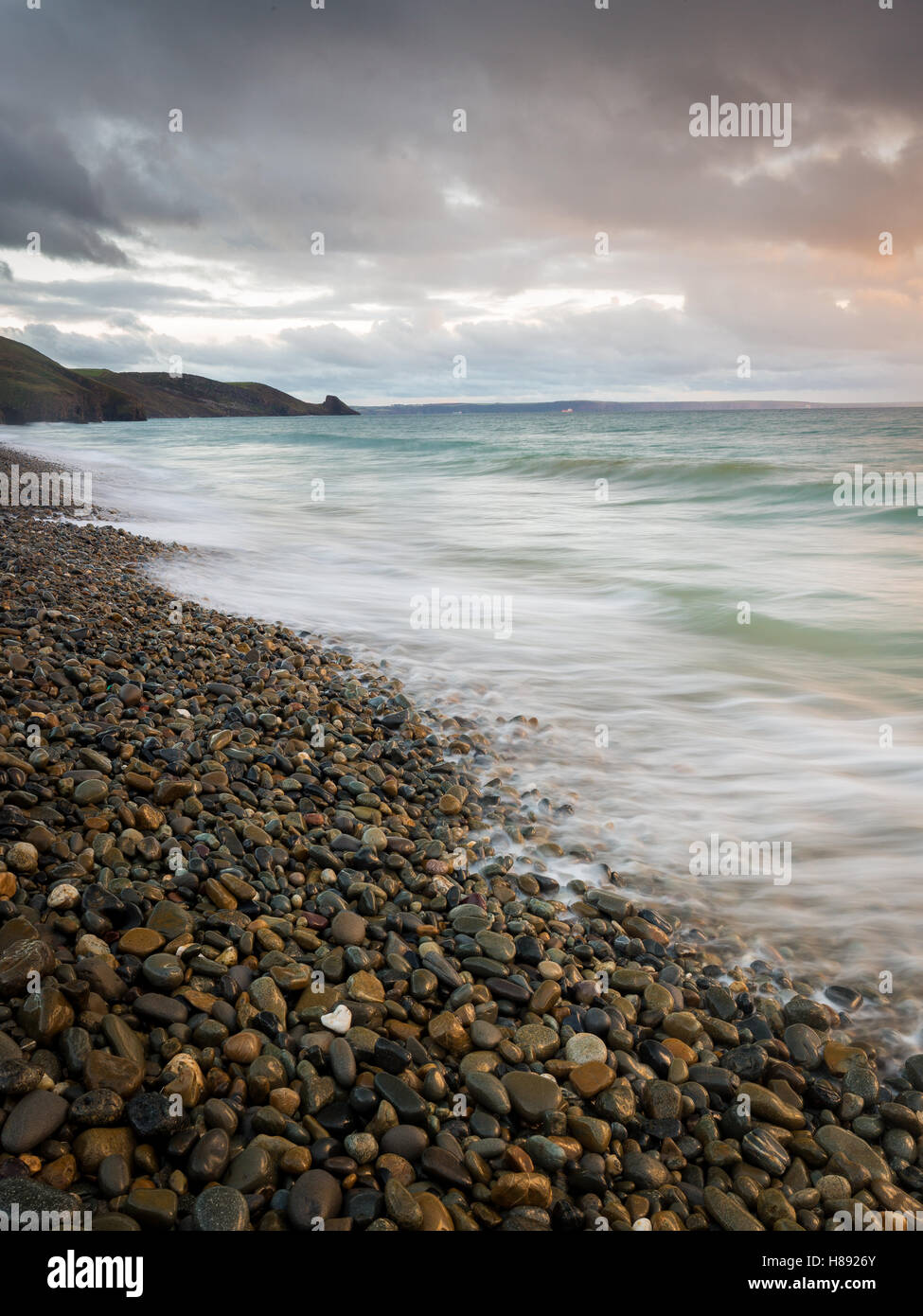 Playa de Newgale y ondas a través de los guijarros, Parque Nacional de la costa de Pembrokeshire, Gales, Reino Unido Foto de stock