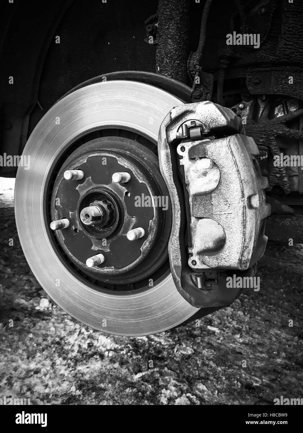 Sustitución de rueda en coche moderno, cerca de la foto en blanco y negro de rotor con freno de disco Foto de stock