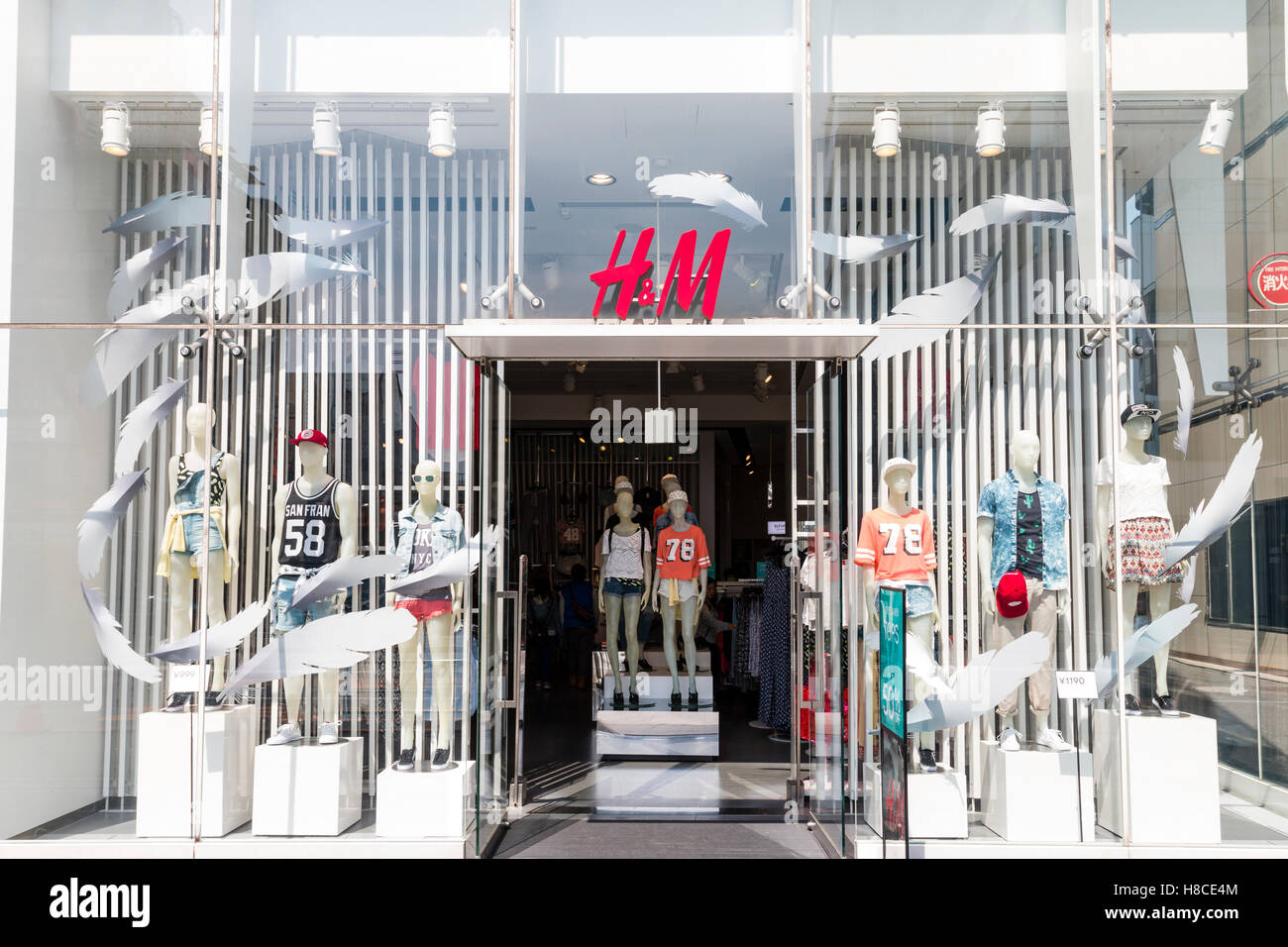 Japón, Tokio, Harajuku. H&M moda tienda de ropa de la cadena de entrada y  la fachada de una tienda, con tema de plumas blancas en la ventana. En  horario diurno Fotografía de