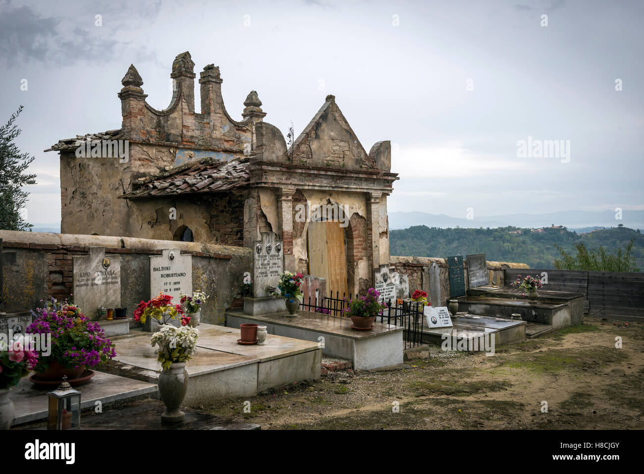 El pequeño cementerio de Toiano, una aldea abandonada en la cima de la colina de la Toscana en Italia Foto de stock