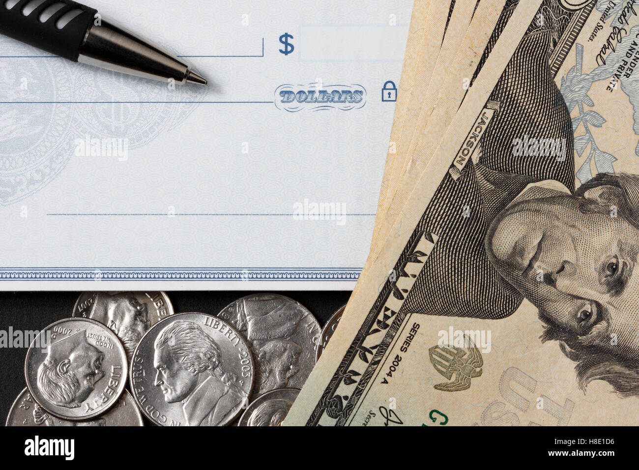 Moneda, un cheque en blanco, veinte dólares billetes y monedas con un lápiz. Foto de stock