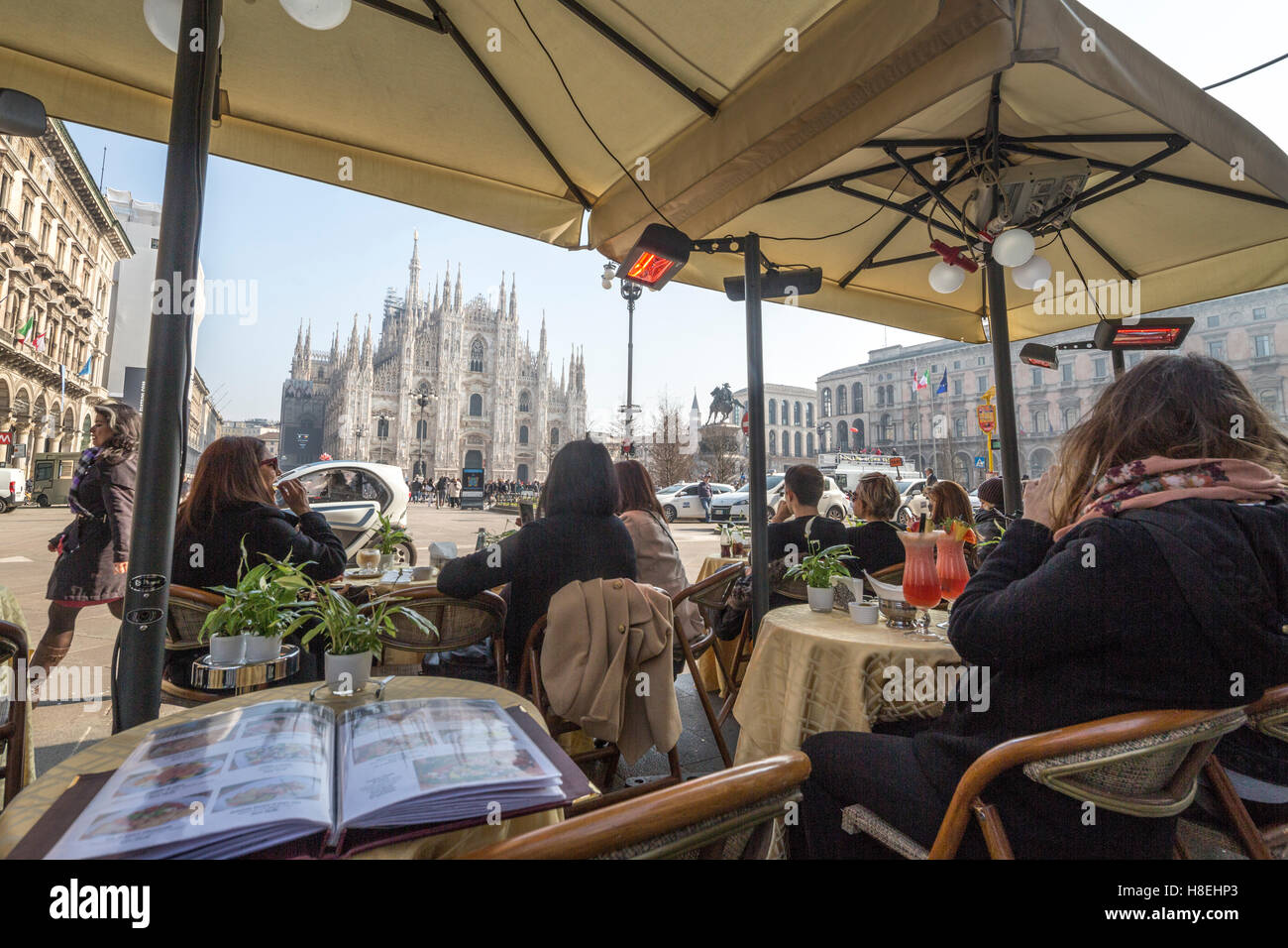 Los turistas en el cafe contemplar la Catedral y su plaza, Milán, Lombardía, Italia, Europa Foto de stock