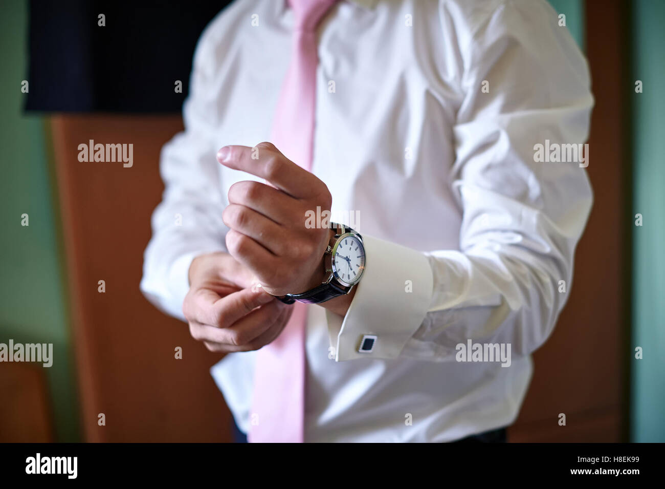 El novio viste un reloj en la mano Foto de stock