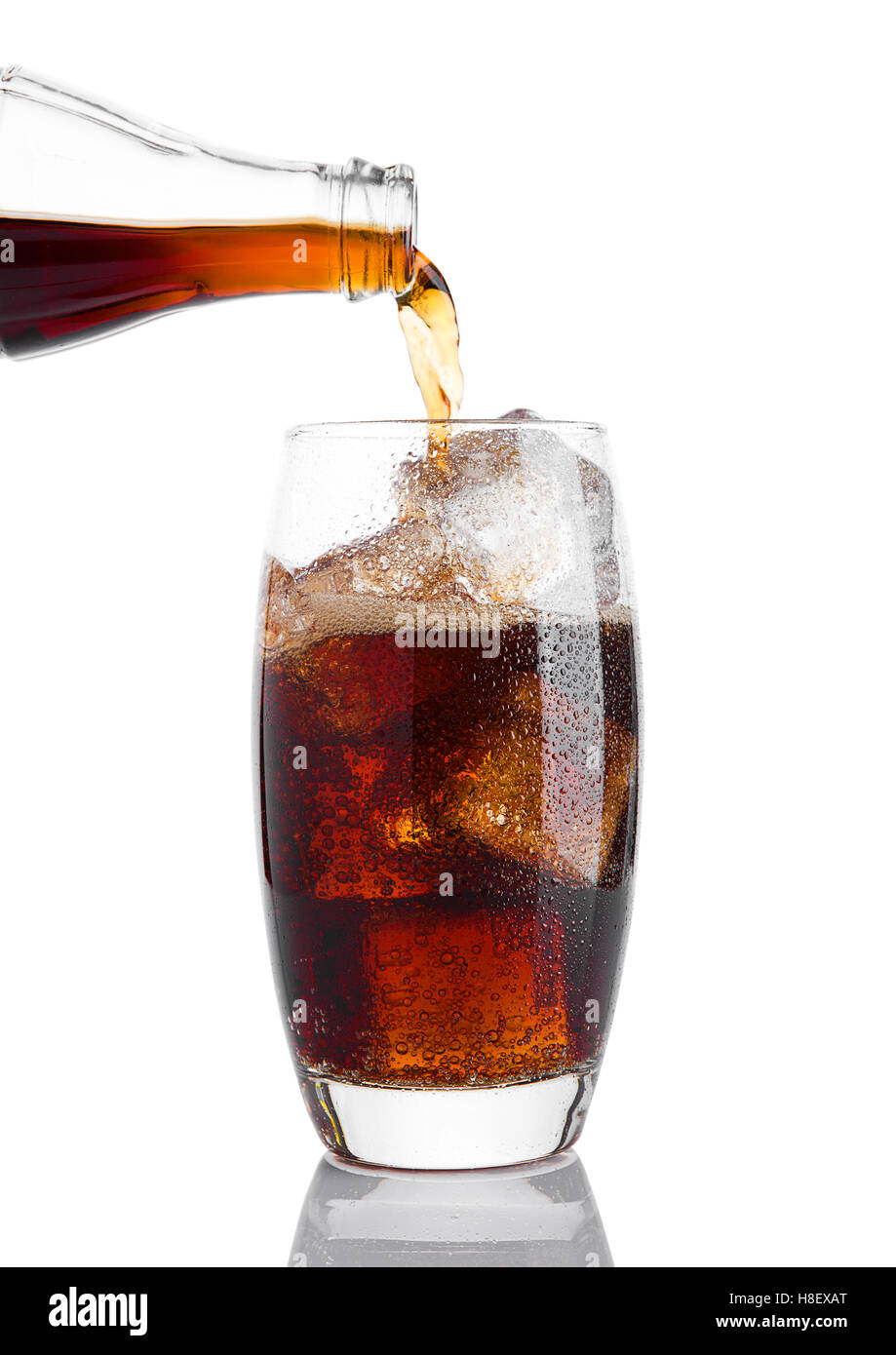 Verter la bebida gaseosa de cola en el vaso con hielo sobre fondo blanco  Fotografía de stock - Alamy