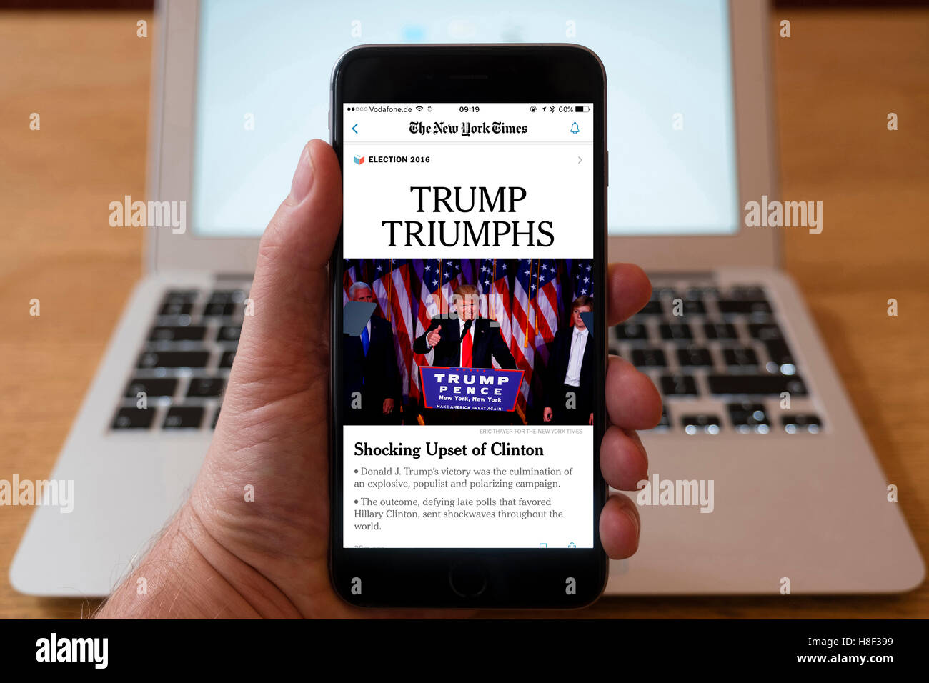 Detalle de iPhone Teléfono Inteligente móvil En línea mostrando la primera página del periódico titular del New York Times después de Donald Trum Foto de stock